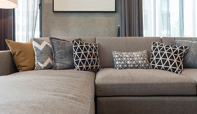 Modern grey sectional couch styled with decorative patterned throw pillows