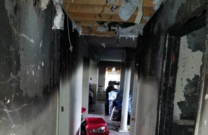 Professional conducting fire damage restoration work on a damaged area.