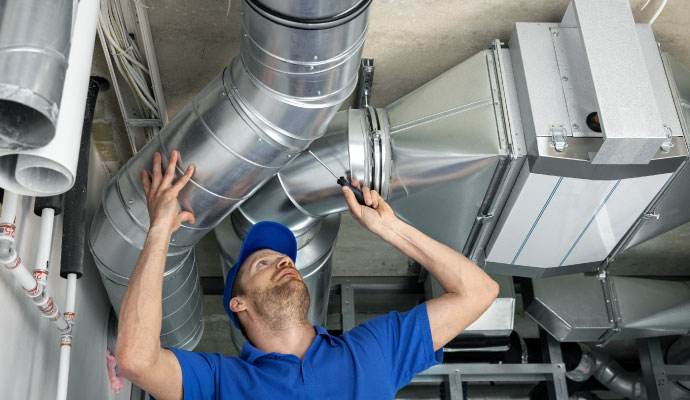 Technician repairing ceiling air duct