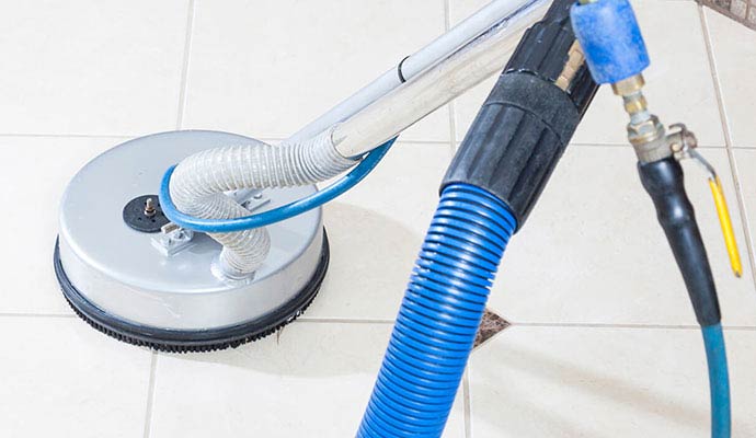 Tile floor cleaning machine with hoses and rotary cleaning head