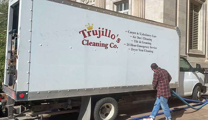 Trujillo's Cleaning Company service truck and technician setting up cleaning hoses