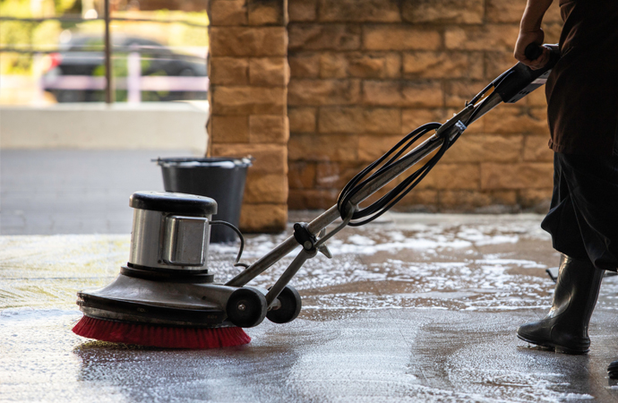 worker cleaning floor with polish machine